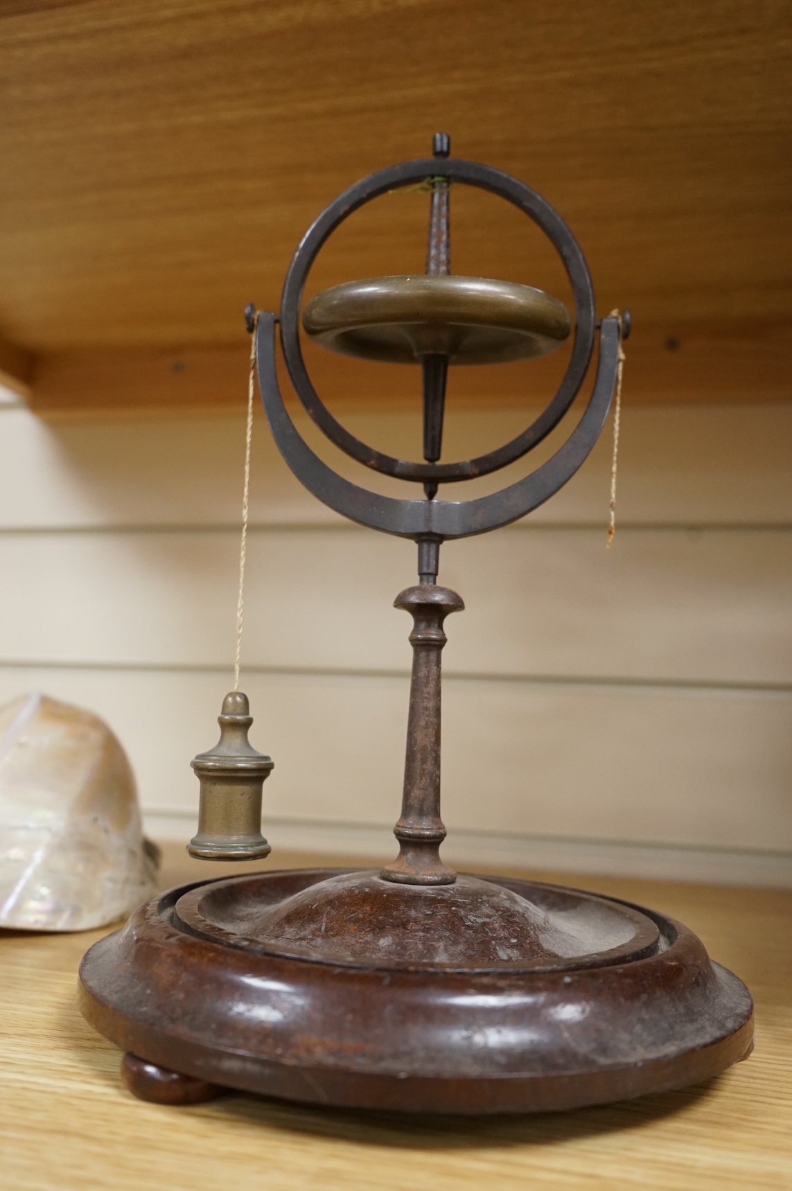 A 19th century brass gyroscope on a turned mahogany base, 26cm high.